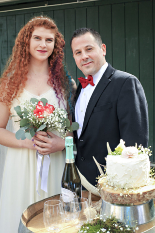 Couple posing with wedding cake